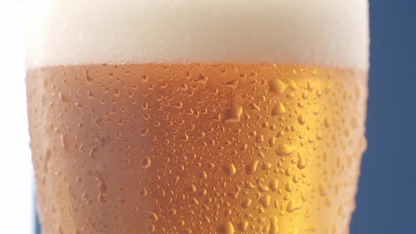 Close Up of Full Beer Mug with Lots of Foam and Drops on Glass in Rotation