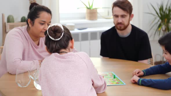 Multinational Family Playing with Board Game Indoors