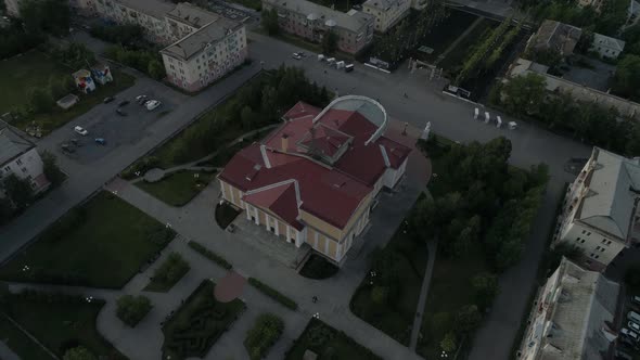 Aerial view of beautiful house of culture square and alley. People walk, cars drive on roads 11
