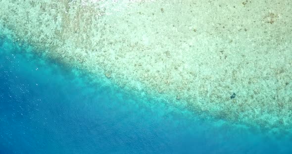 Wide angle above copy space shot of a sunshine white sandy paradise beach and aqua blue water backgr