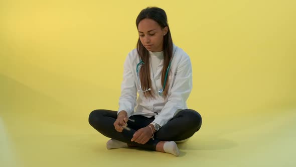 Tired Black Female Doctor Putting Eyeglasses and Stethoscope Off