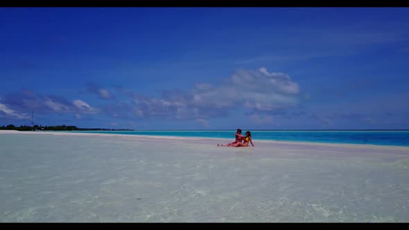 Two people happy together on paradise coastline beach time by turquoise sea and white sandy backgrou