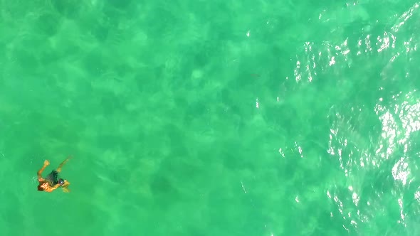 Aerial view of a man swimming in a green lake