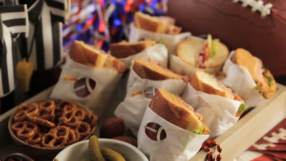 Game day football party table with  sub sandwich and snacks.