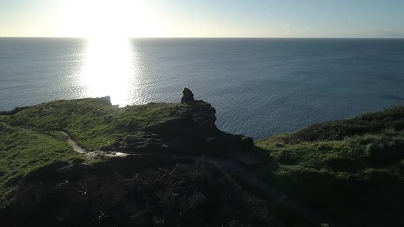 Young woman looking out at the beautiful ocean view, aerial shot