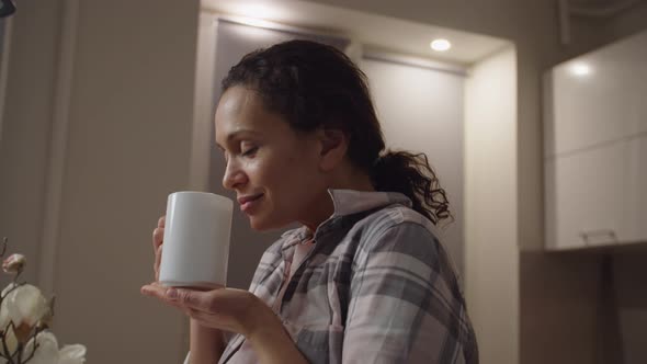 Portrait of Adult Woman Holding White Mug with Hot Beverage at Home