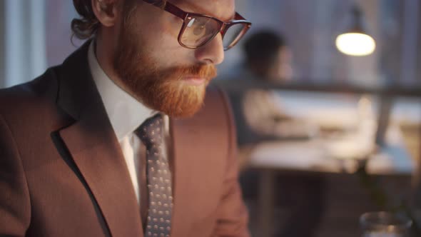 Close Up of Caucasian Businessman Typing on Laptop in the Evening