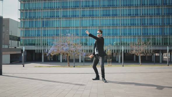 Flexible and cool businessman doing acrobatic tricks outdoor.