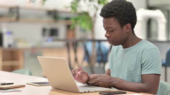 Young African Man with Laptop Having Wrist Pain