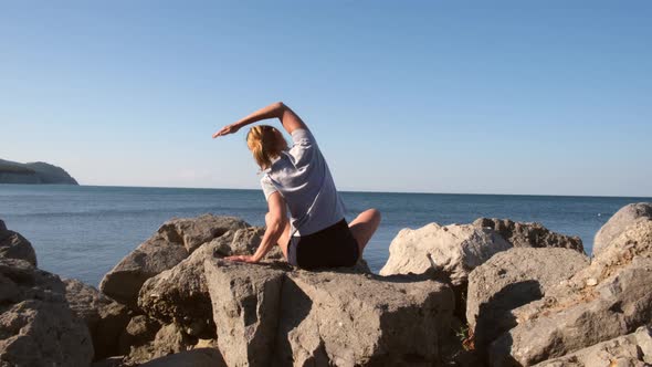 Young Caucasian Woman Doing Stretching Exercises at the Seashore