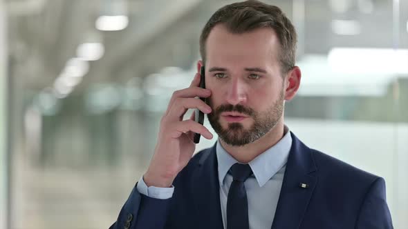 Portrait of Cheerful Businessman Talking on Phone