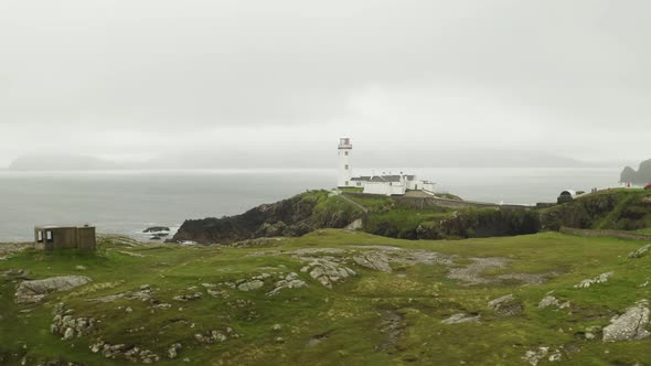 Aerial establishing shot of solitary lighthouse at Fanad Head, northern Ireland