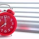 Red alarm clock rang early morning eight clock morning, against background of closed blinds. - VideoHive Item for Sale