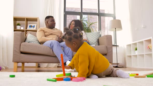Mother, Father and Baby Playing Toy Blocks at Home
