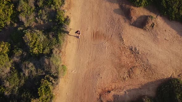 Faceless sportswoman jogging on picturesque seashore