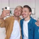 Homosexual Couple Hugging Looking at Smartphone Camera When Making Selfie Photos - VideoHive Item for Sale