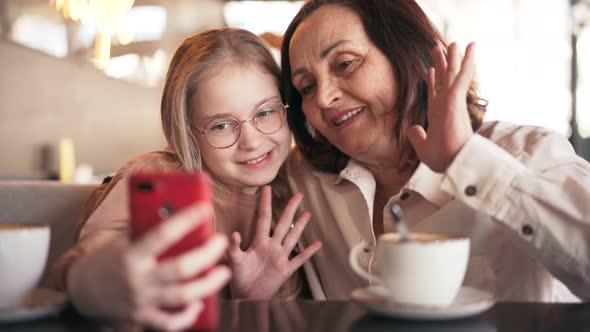 Happy Grandmother and Cute Granddaughter Taking Selfies on the Phone Together