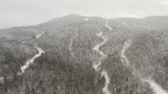 Rivers flow through dense mountainous forestry landscape dusted with fresh snow