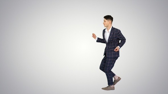 Cool man in formal outfit walking and dancing on gradient