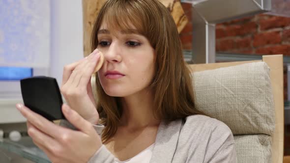 Young Woman Applying Make Up on Her Face