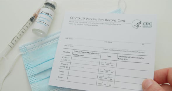 Medical Mask and COVID19 Vaccine Doctor Hand Put Vaccination Record Card Approved By CDC with Corona