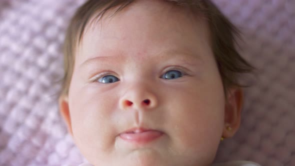 Closeup of Baby Girl with Beautiful Eyes Looking at Camera