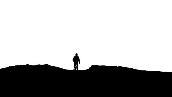 Man Approaches Over Hill Silhouette