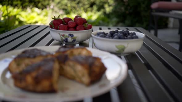 Blueberries in bowl with frittata.  Bright foliage in distance. Slider Left to Right Slide