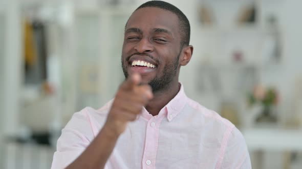 Portrait of Smiling African Man Pointing with Finger 