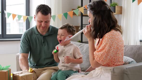 Happy Family with Gifts and Party Blowers at Home