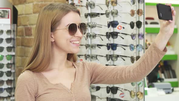 Happy Young Woman Taking Selfies While Shopping for Eyewear