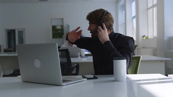 Nervous Man Does His Online Work in Headphones