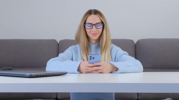 Cheerful young female communicating online on social media app with new mobile phone in 4k video