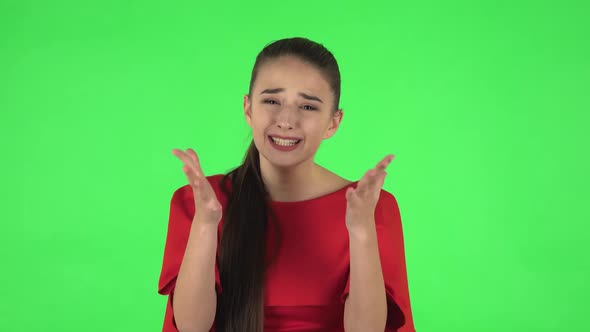 Portrait of Pretty Young Displeased Woman Is Indignantly Talking To Someone. Green Screen