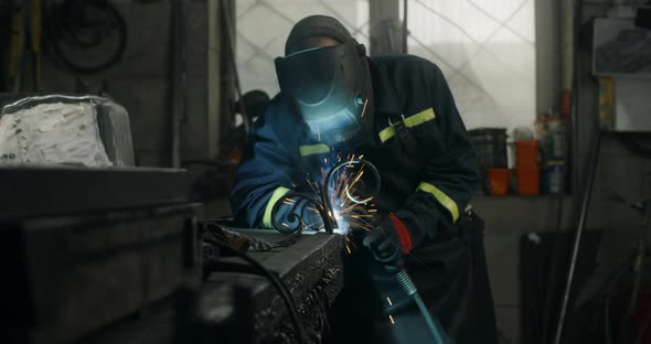 Welder Welds Metal Details in Safety Uniform at His Workroom Welding and Metalwork at Blacksmith's