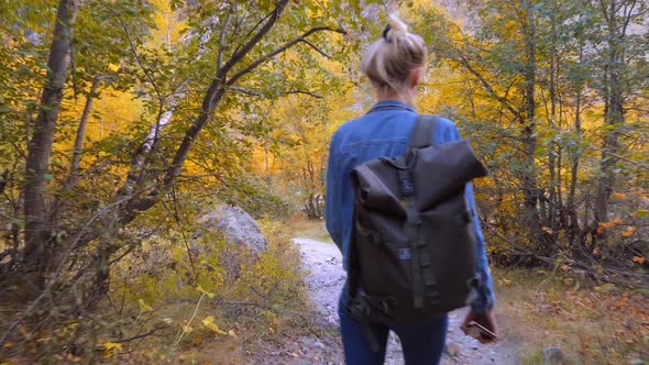 A young beautiful slender woman alone in the mountains.