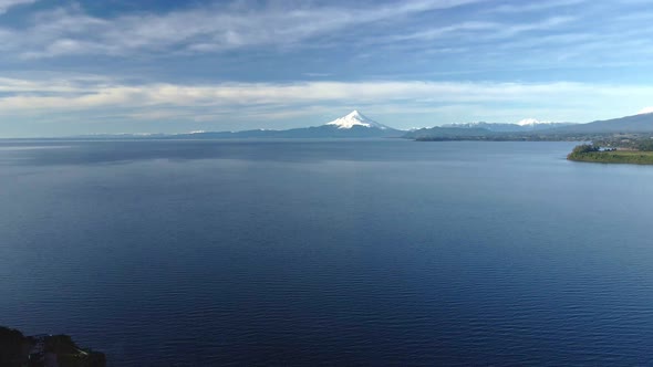 Dolly out aerial view of Lake Llanquihue with Osorno volcano in the background, Puerto Varas, Chile