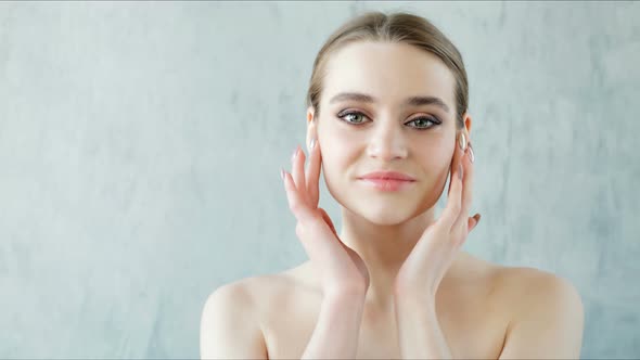 Beautiful Young Woman with Clean and Healthy Skin Posing on Grey Background