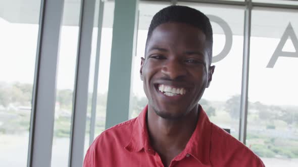 Portrait of laughing african american creative businessman in modern office interior