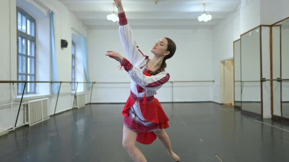 Zoom in to Smiling Beautiful Young Woman in Ukrainian National Costume Dancing Folk Dance in Studio