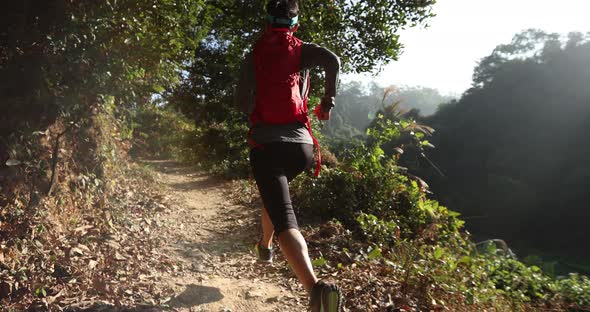 Woman trail runner running at sunrise tropical forest ,slow motion