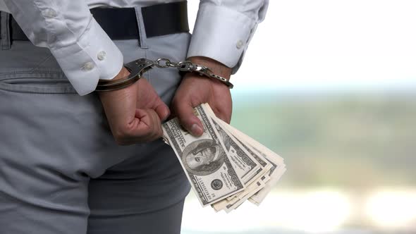 Man in Handcuffs Holding Money.