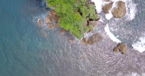 Aerial top down view natural landscape ocean waves splashing in a beach in Indonesia, Southeast Asia