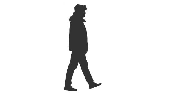 Silhouette of Adult Man Walking in Winter Clothes alt