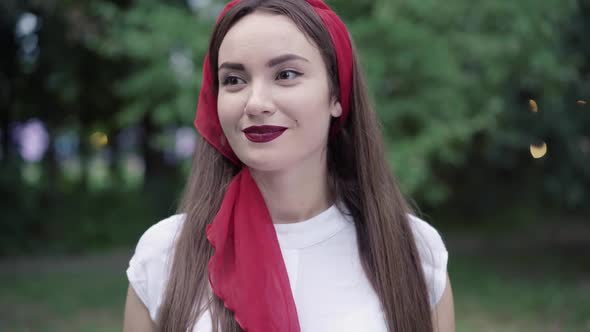 Close-up Portrait of Charming Slim Brunette Woman with Brown Eyes Standing in Summer Park and