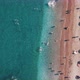 Aerial Top View of Beach with Sunshade and People Swimming at Beautiful Blue Color Sea - VideoHive Item for Sale