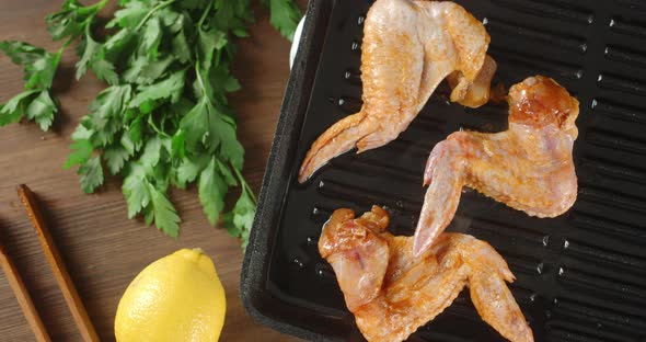 Fried Chicken Wings with Hot Steam Rotate in a Frying Pan. 