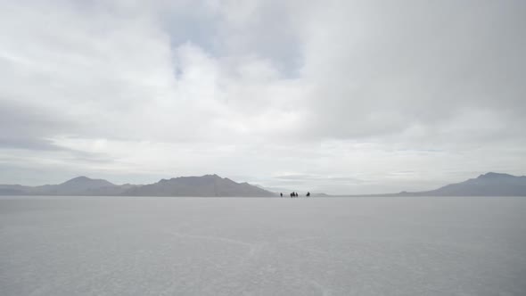 Horses running from the far distance to up close with cowboys pushing them