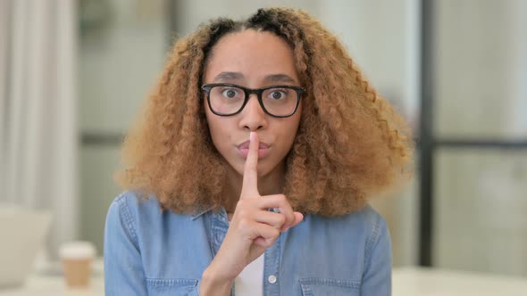 Portrait Shot of African Woman Showing Quiet Sign Finger on Lips