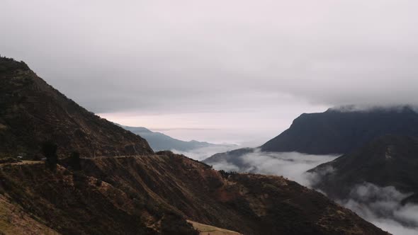 Road in the Ecuadorian andes at sunset. Aerial shot of the clouds and mountains.